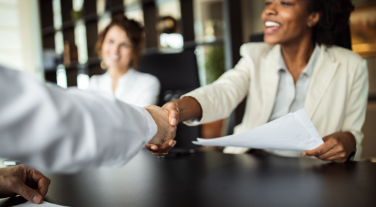 Jeune femme qui serre la main d'un collaborateur