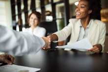 Jeune femme qui serre la main d'un collaborateur